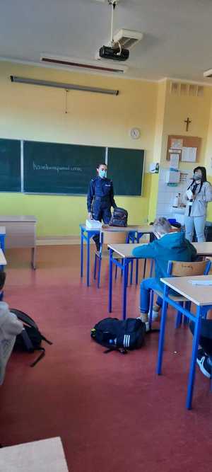 umundurowana policjantka prowadzi lekcje z uczniami klasy VIII