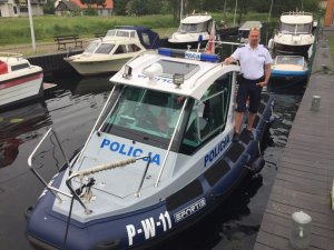 umundurowany policjant stoi przy łodzi policyjnej