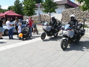 dwóch umundurowanych policjantów na motocyklach oznakowanych wśród dzieci