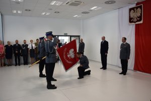 Komendant Powiatowy Policji w Goleniowie ,klęcząc na prawe kolano całuję sztandar Komendy Powiatowej Policji w Goleniowie.